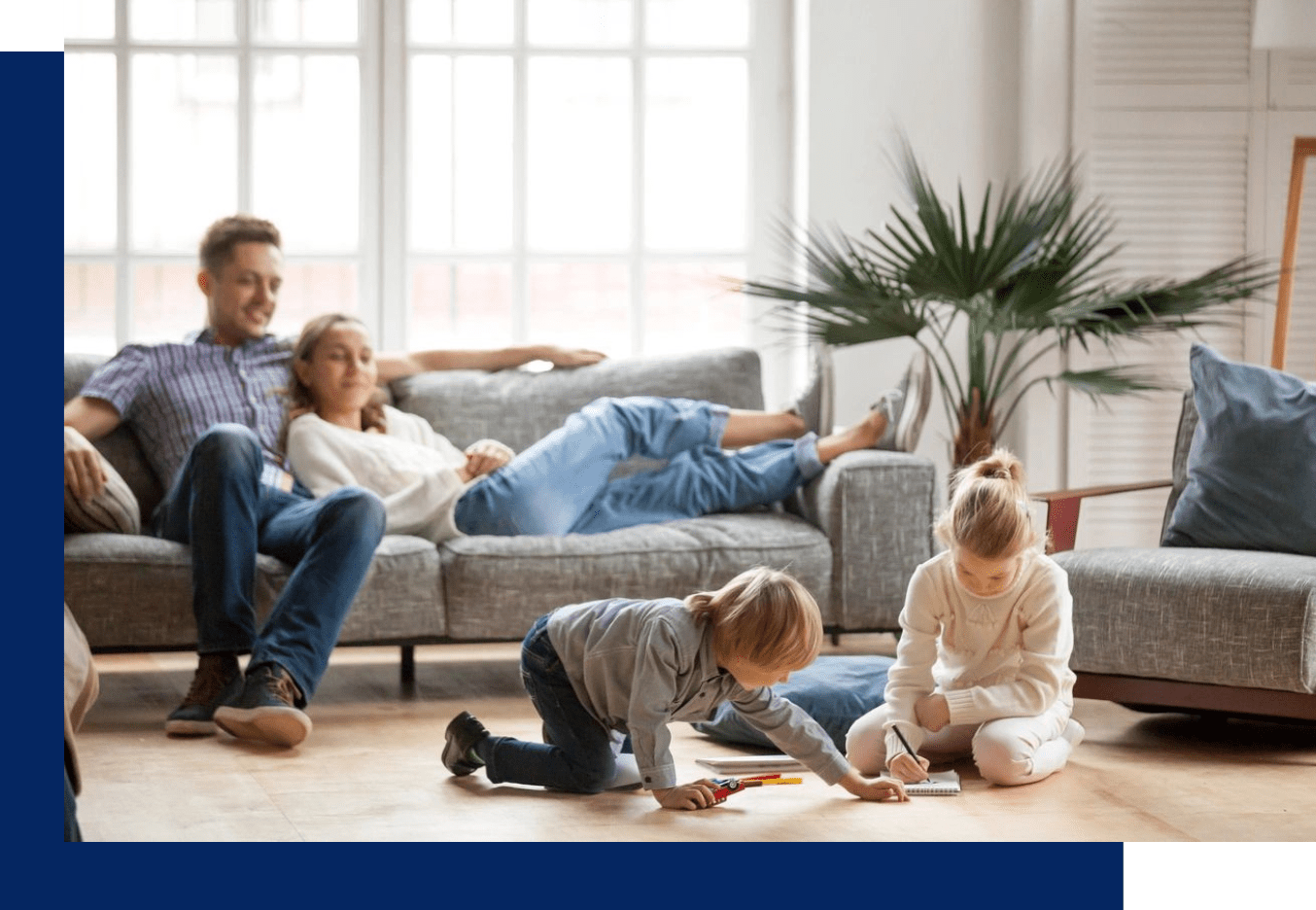 A family sitting on the floor in front of a couch.